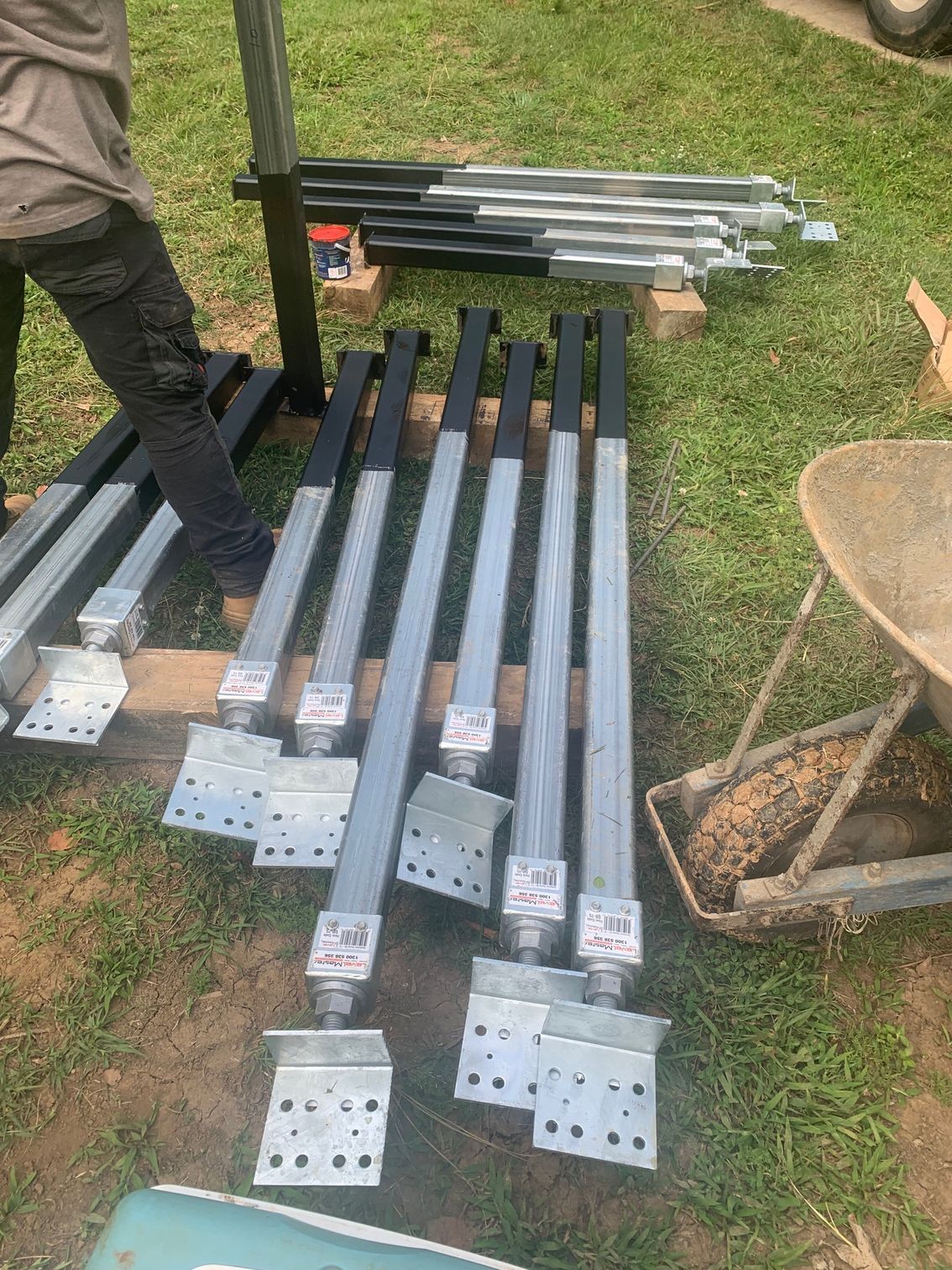 A bunch of metal poles are sitting on top of each other on the grass.