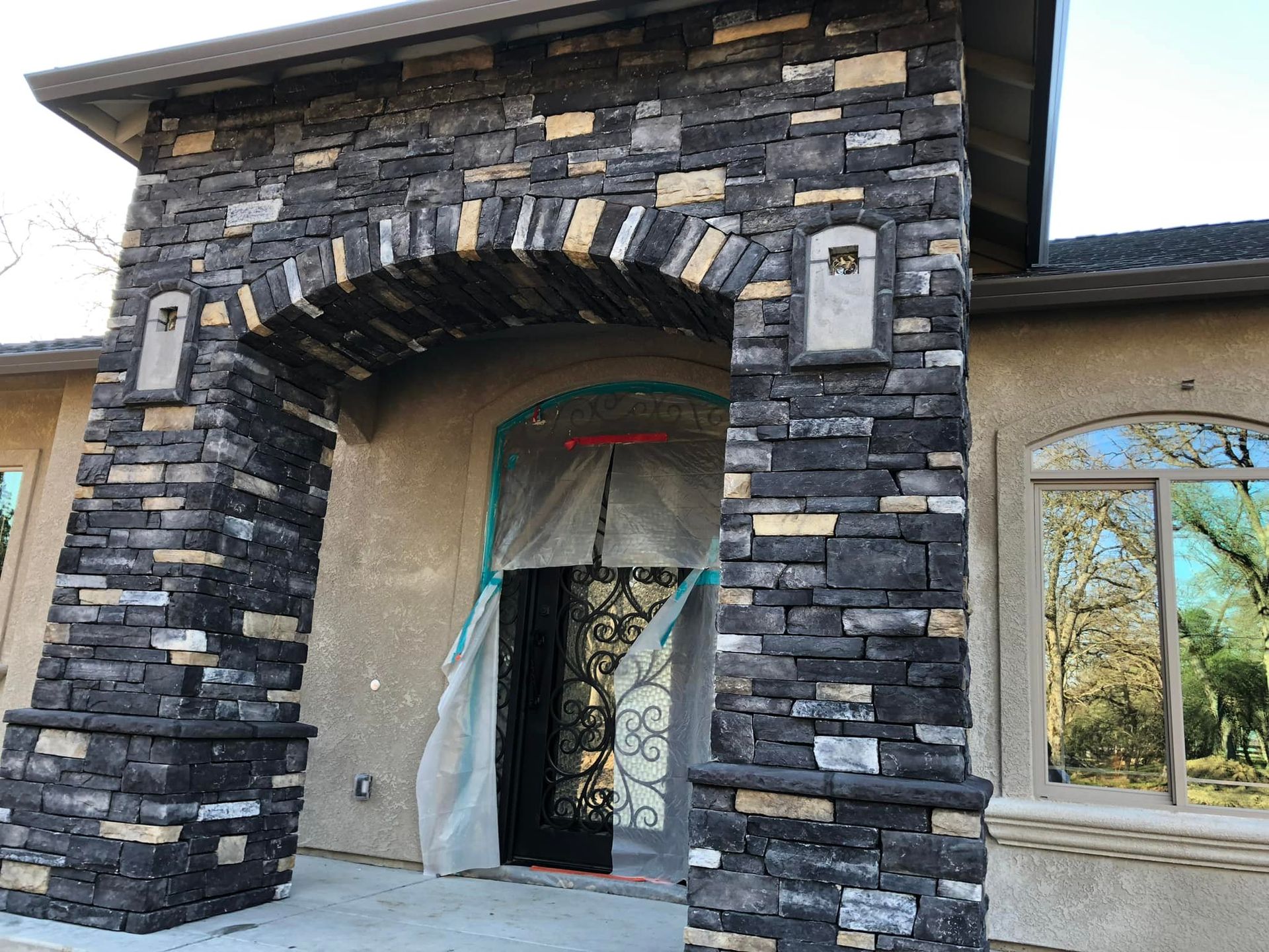 The front of a house with a stone archway and a mailbox.
