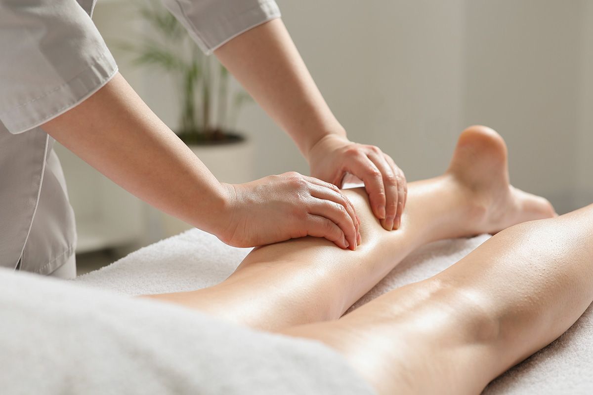 a woman is getting a massage on her leg in a spa