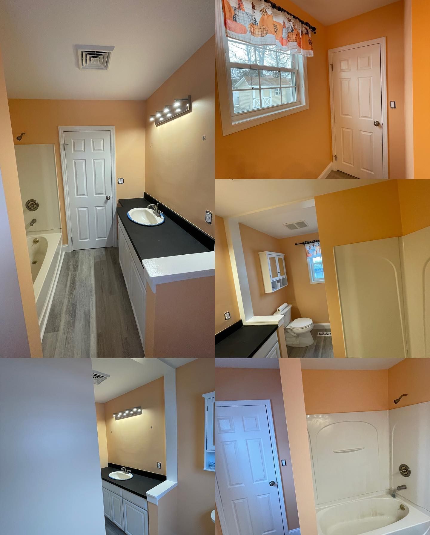 A bathroom with orange walls , a sink , a toilet , and a bathtub.