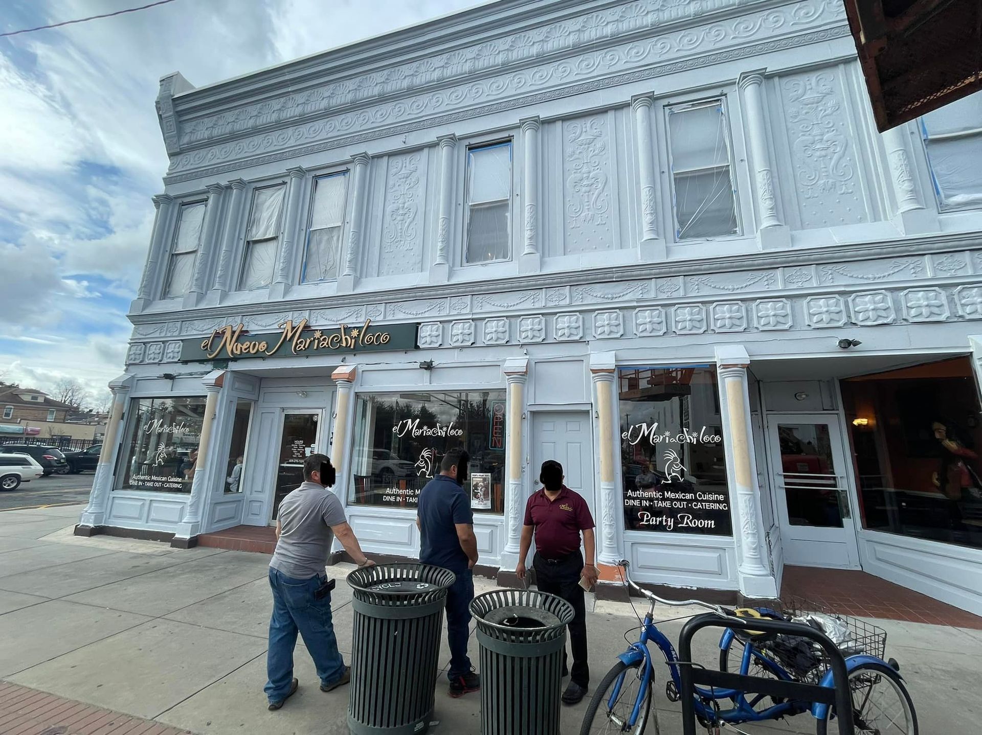 A group of men are standing in front of a large white building.
