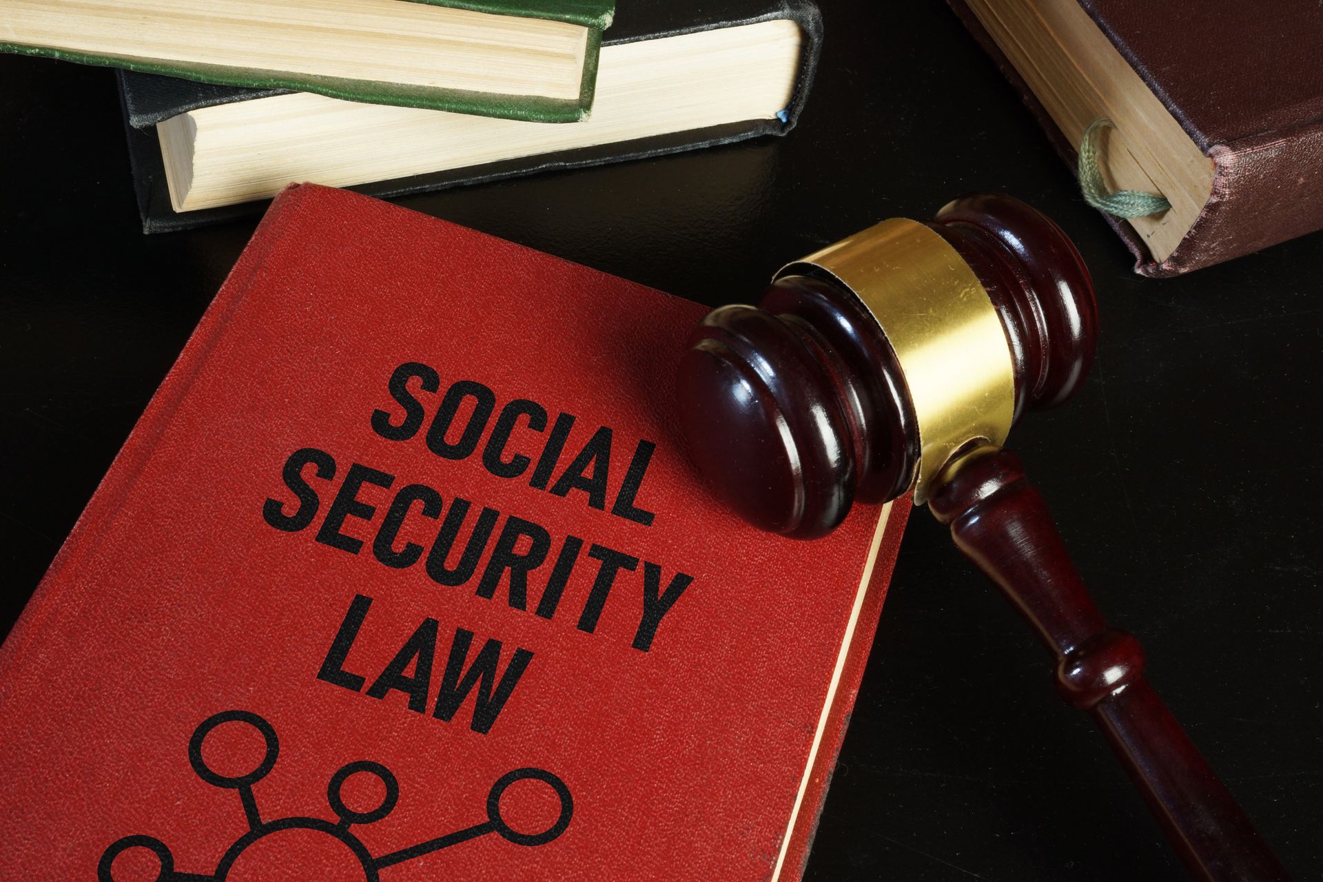 A Social Security law book lies on a desk with a judge’s gavel placed next to it.