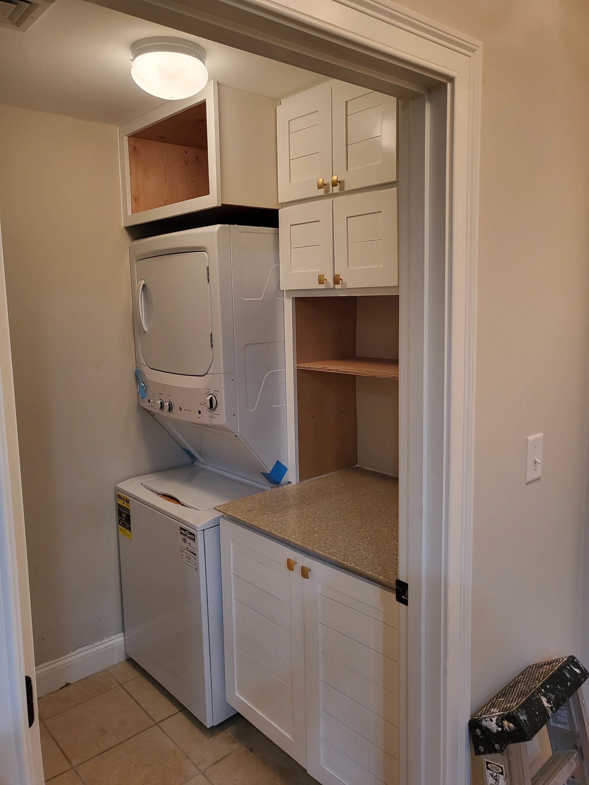 A laundry room with a washer and dryer and a refrigerator.