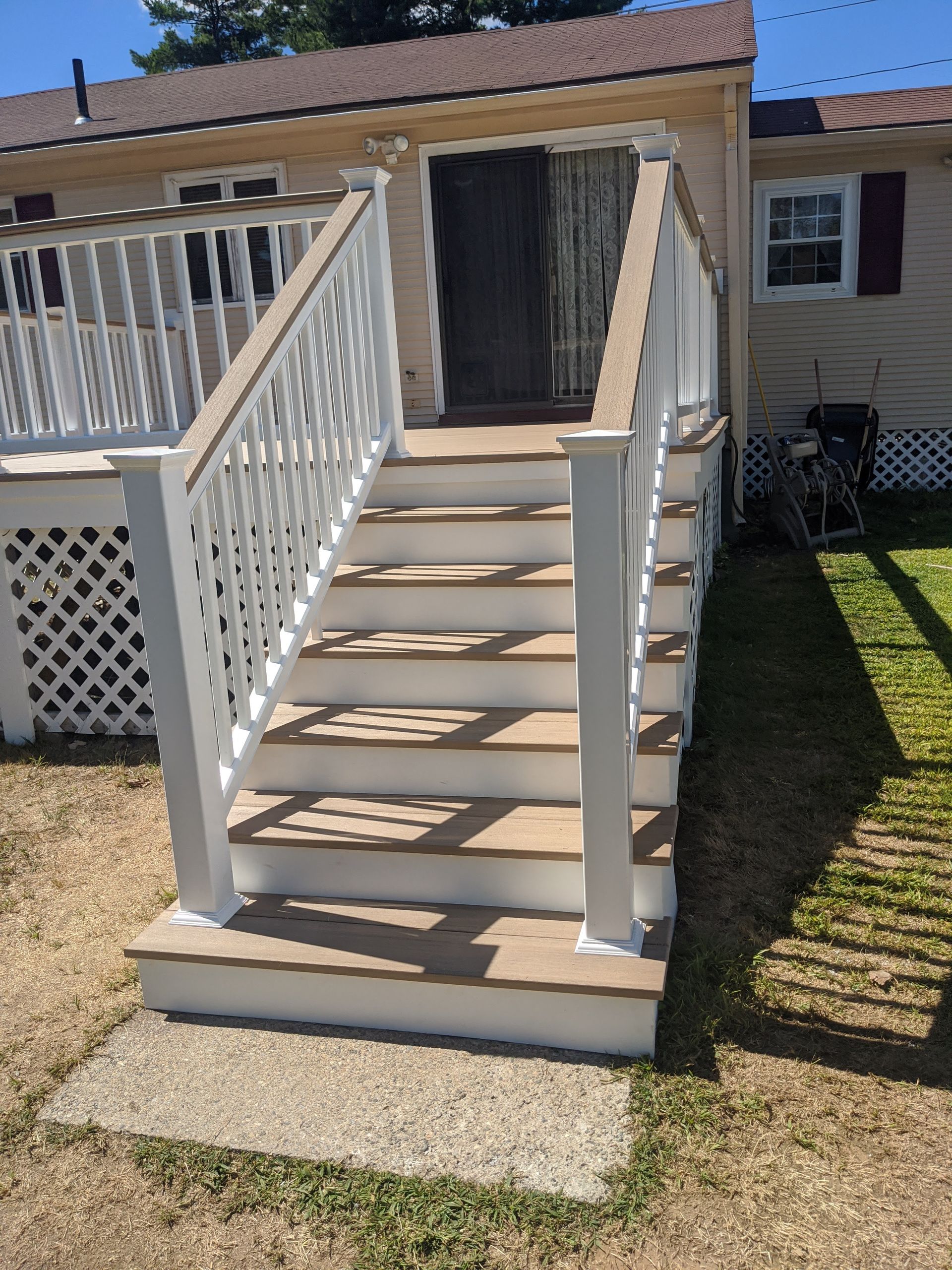 A set of stairs leading up to a house with a white railing
