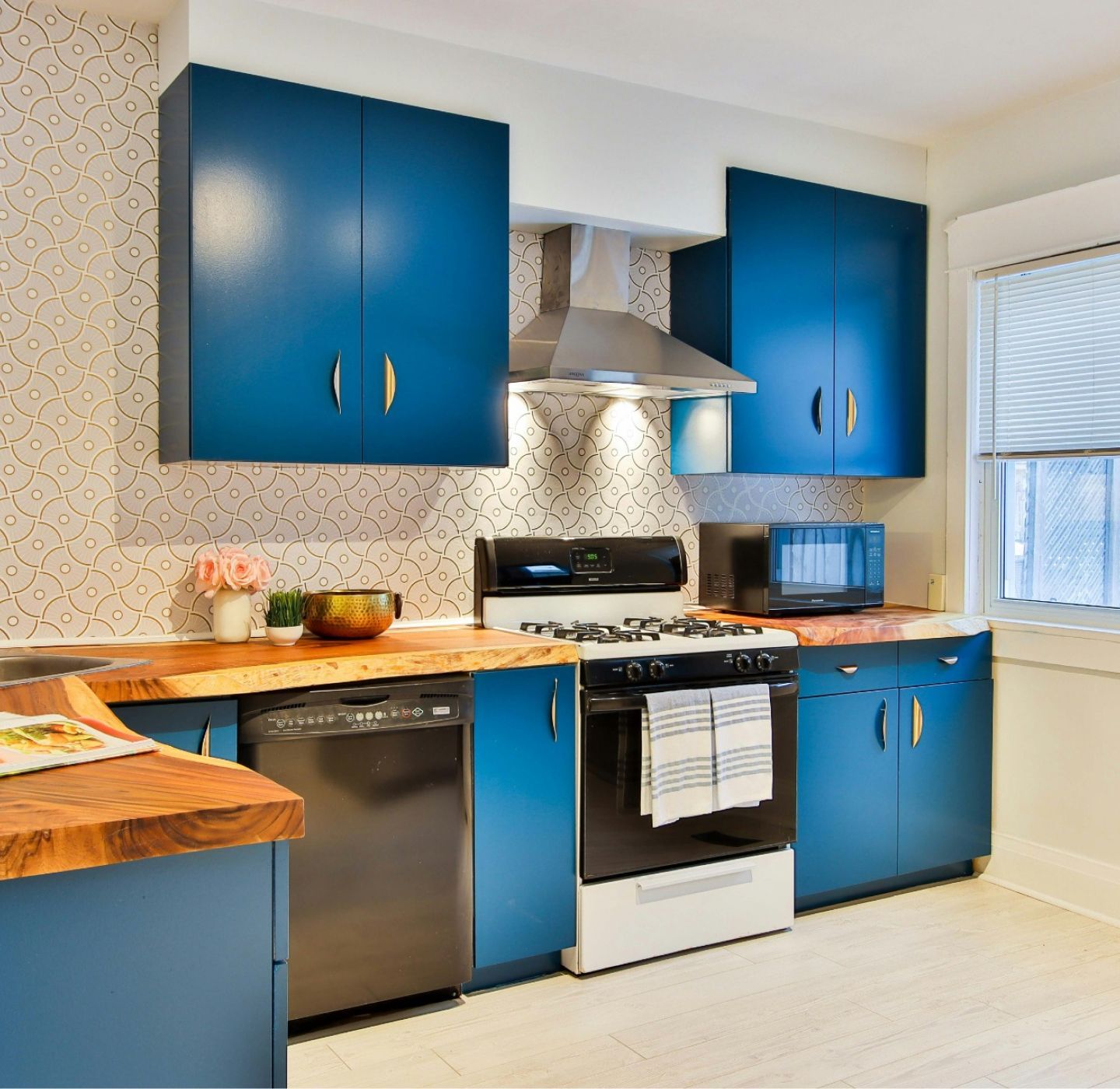 A kitchen with blue cabinets and a black stove