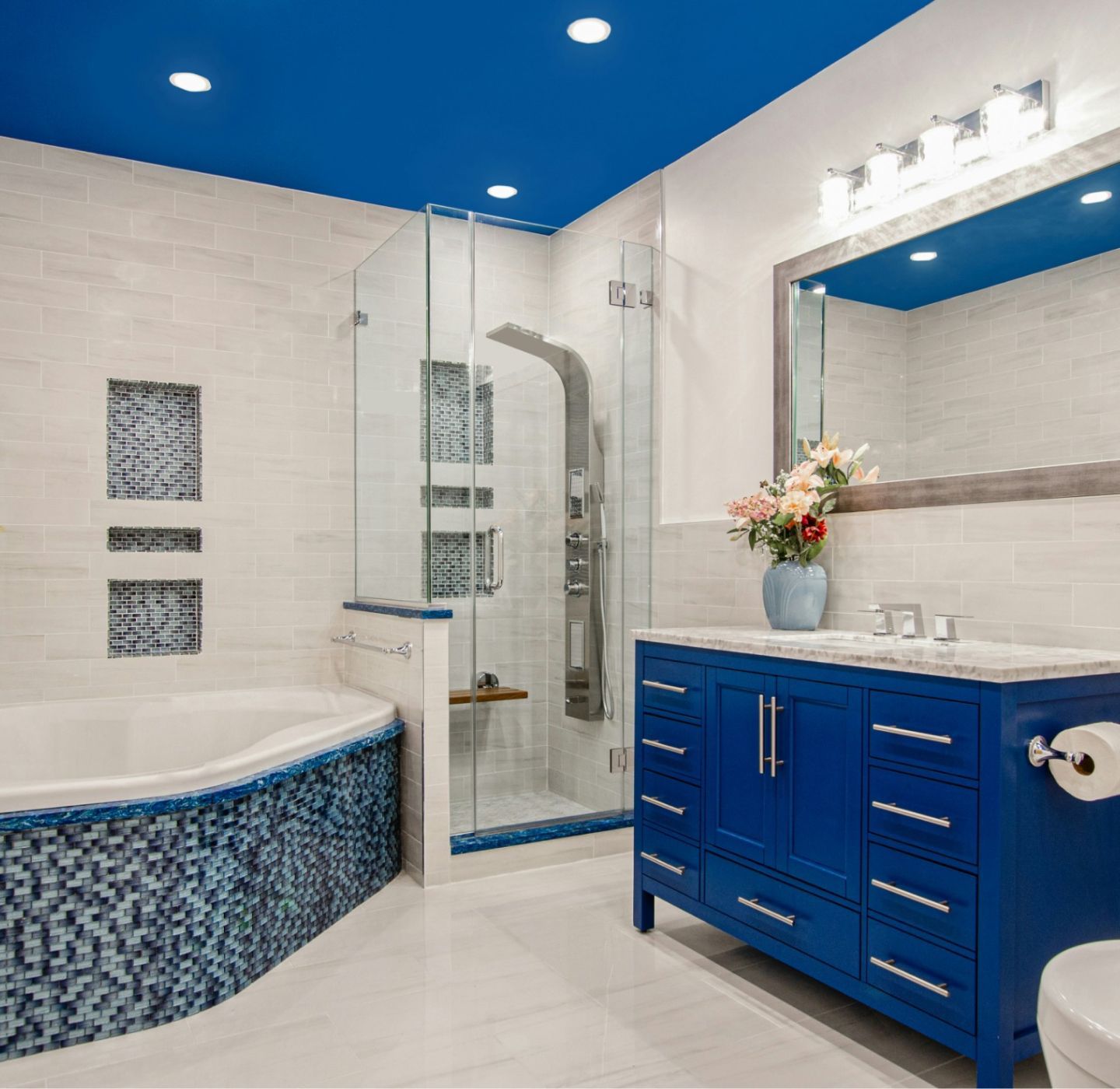 A bathroom with blue cabinets and a blue tub