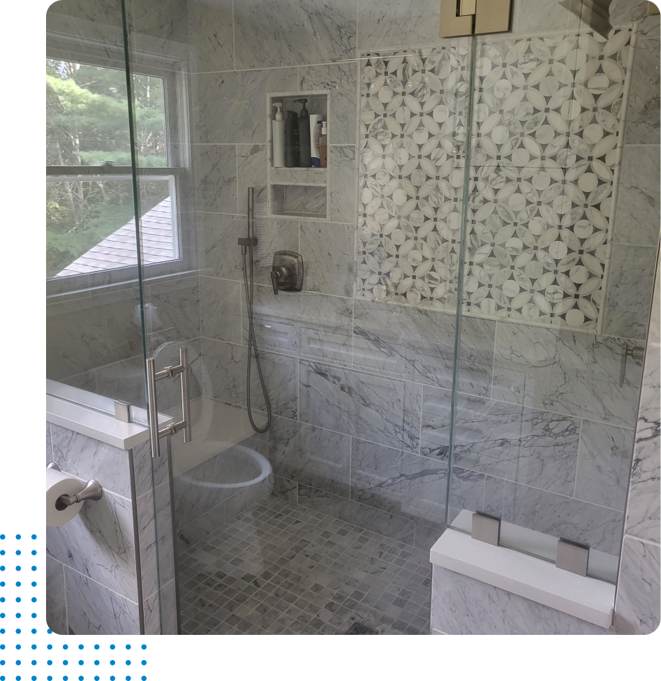 A bathroom with marble tiles and a walk in shower