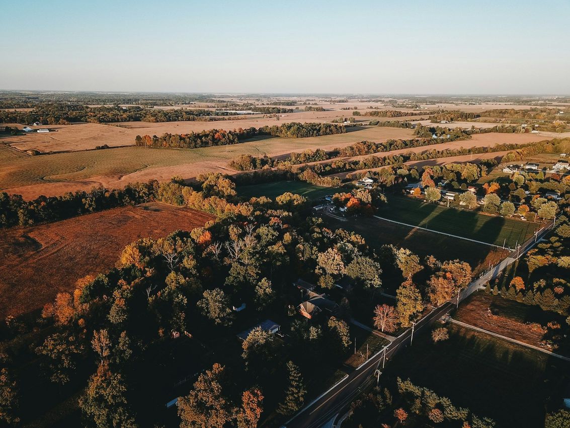 An aerial view of a landscape with trees and fields