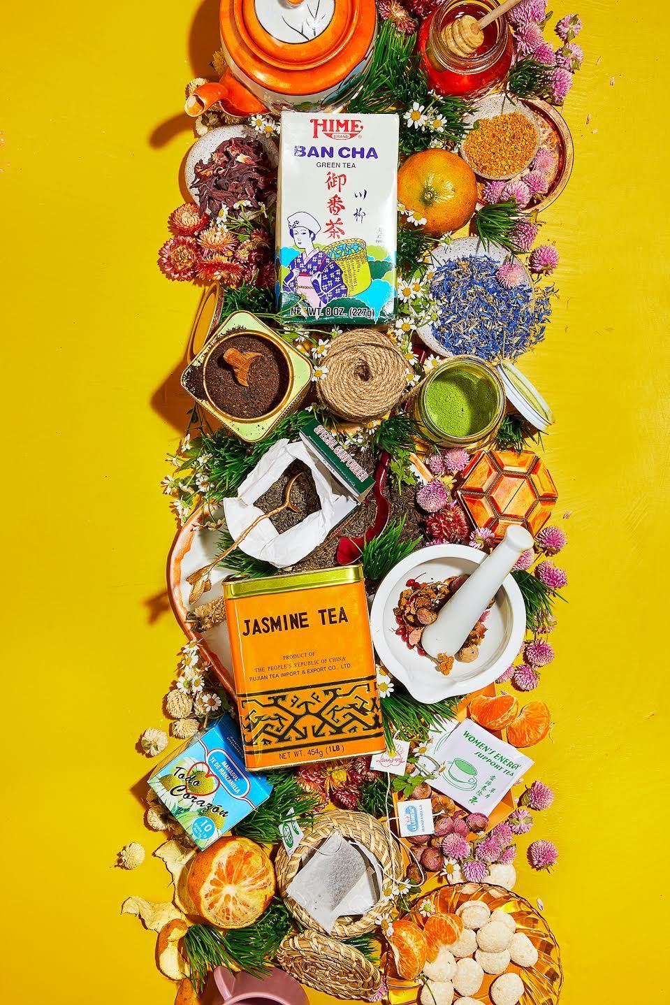 Various teas and ingredients arranged vertically against a yellow background. Food Stylist Nadine Page.