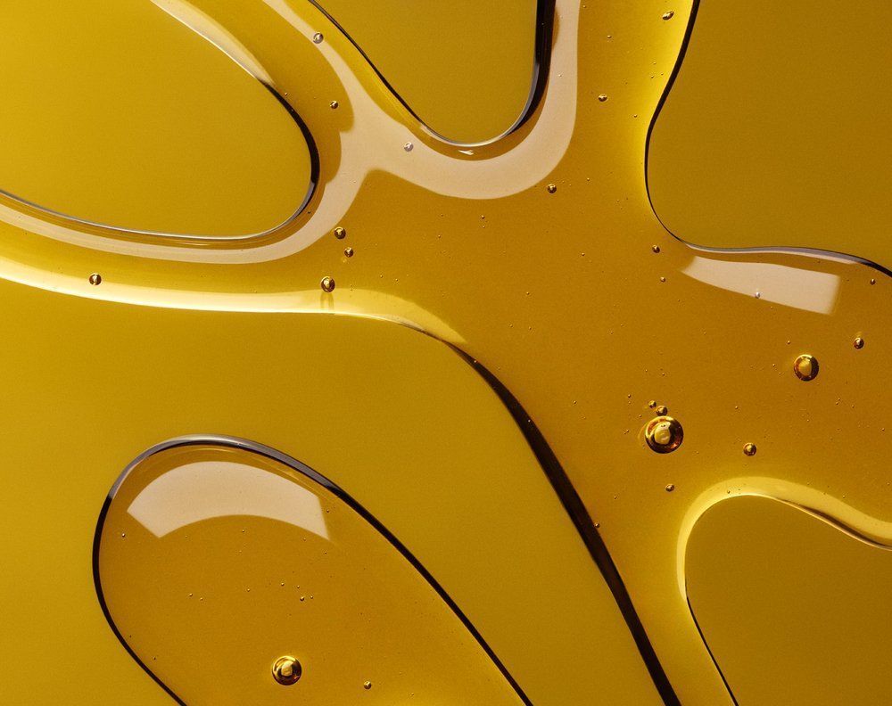 Golden, viscous liquid with organic, flowing shapes, possibly honey, on a similarly colored surface. Food Stylist Nadine Page.