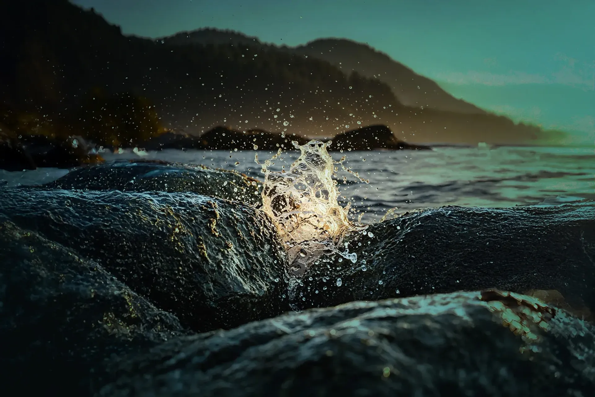 Wave crashing against rocks, the splash of which caught the sunlight so as to look like a