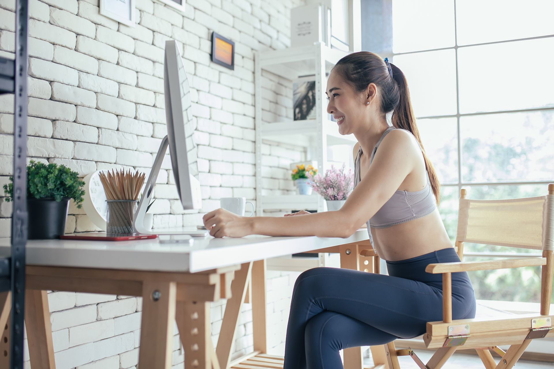 Woman at desk using laptop, Urbandog Media