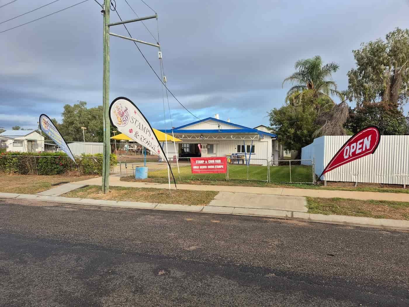A House With a Sign That Says Open in Front of It — John Platts Stamps & Coins In Mackay, QLD