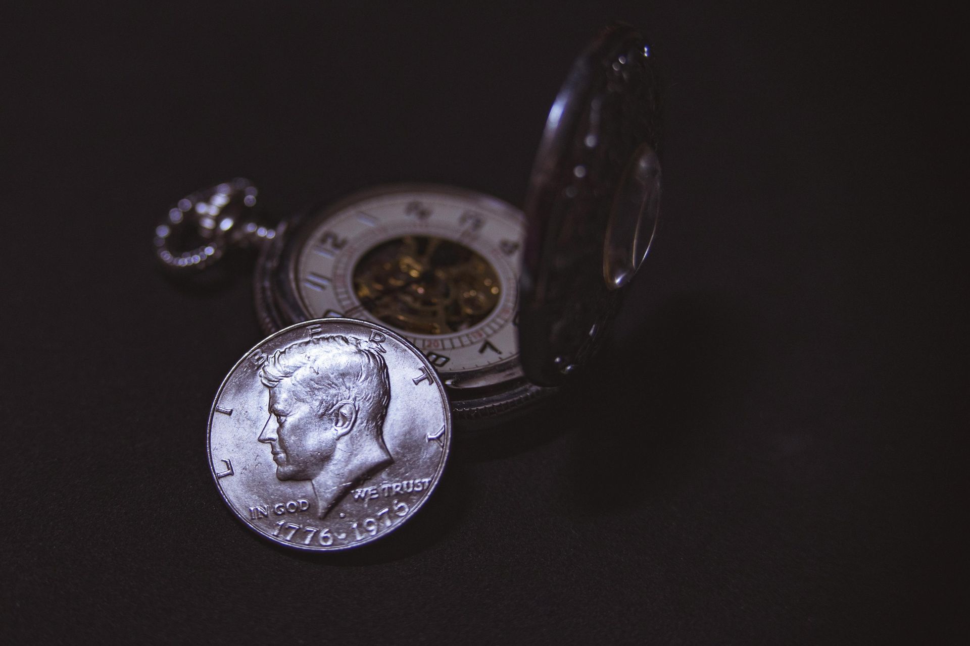 A Close Up of a Pocket Watch and a Coin on a Table — John Platts Stamps & Coins In Cairns, QLD