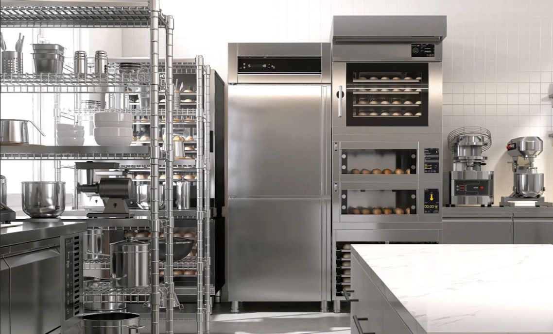 Stainless steel commercial kitchen with shelving, refrigerator, oven, and prep area.