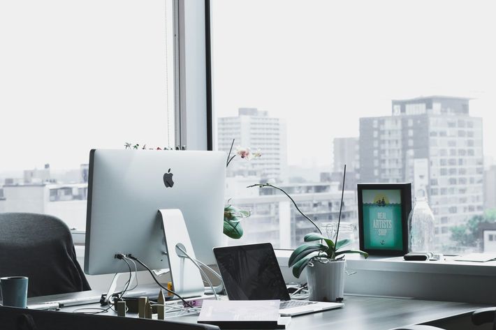 a desk with a computer and a laptop on it .