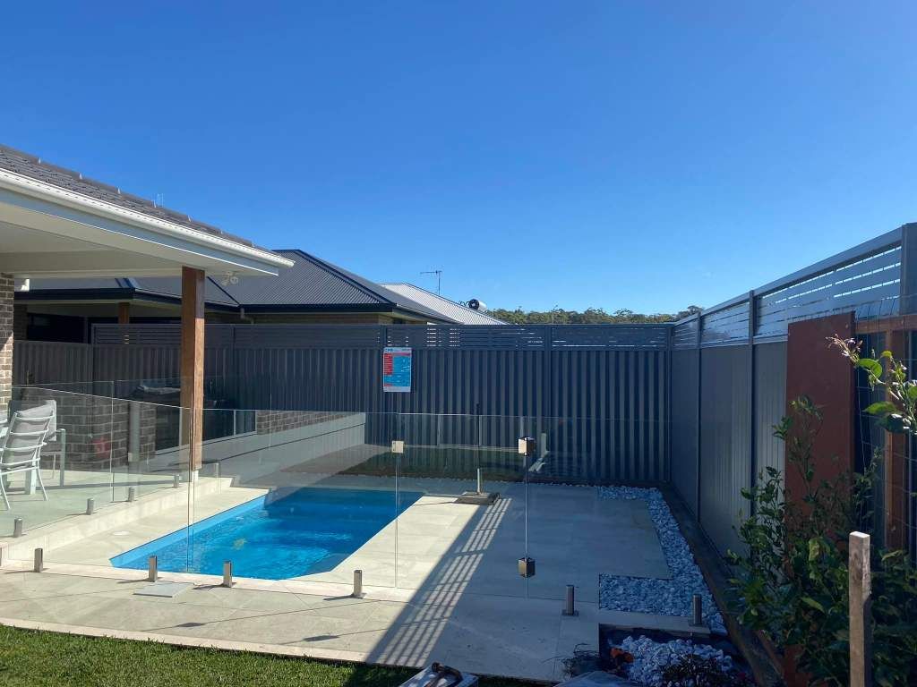 There Is A Large Swimming Pool In The Backyard Of A House — Arecta Fence In Lakewood, NSW