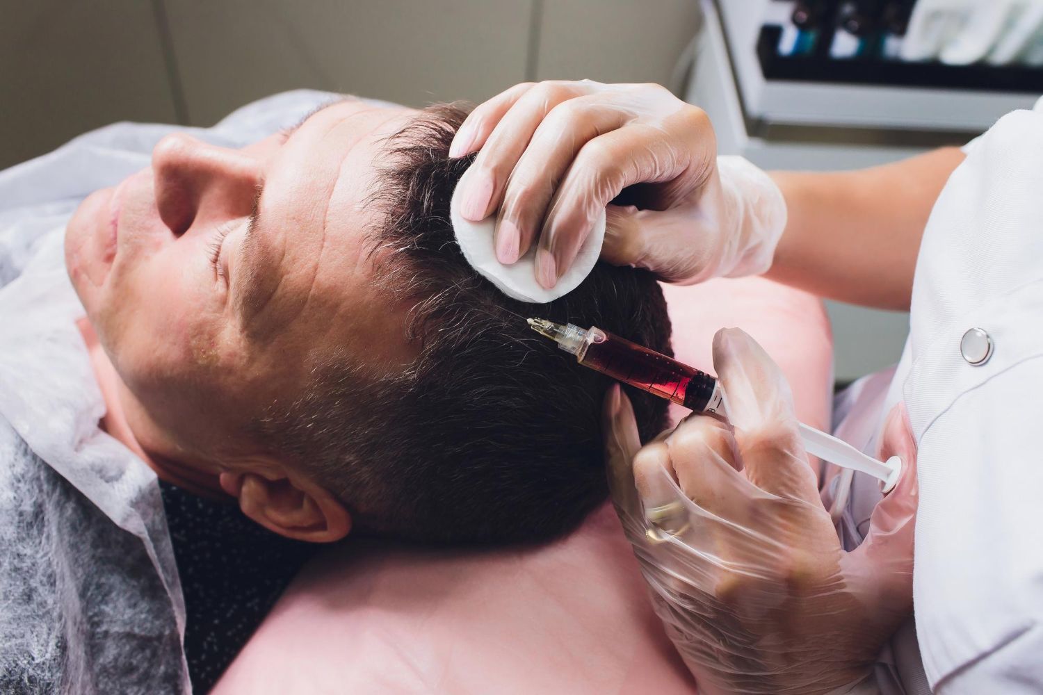 A man is getting an injection in his head at a hair salon.