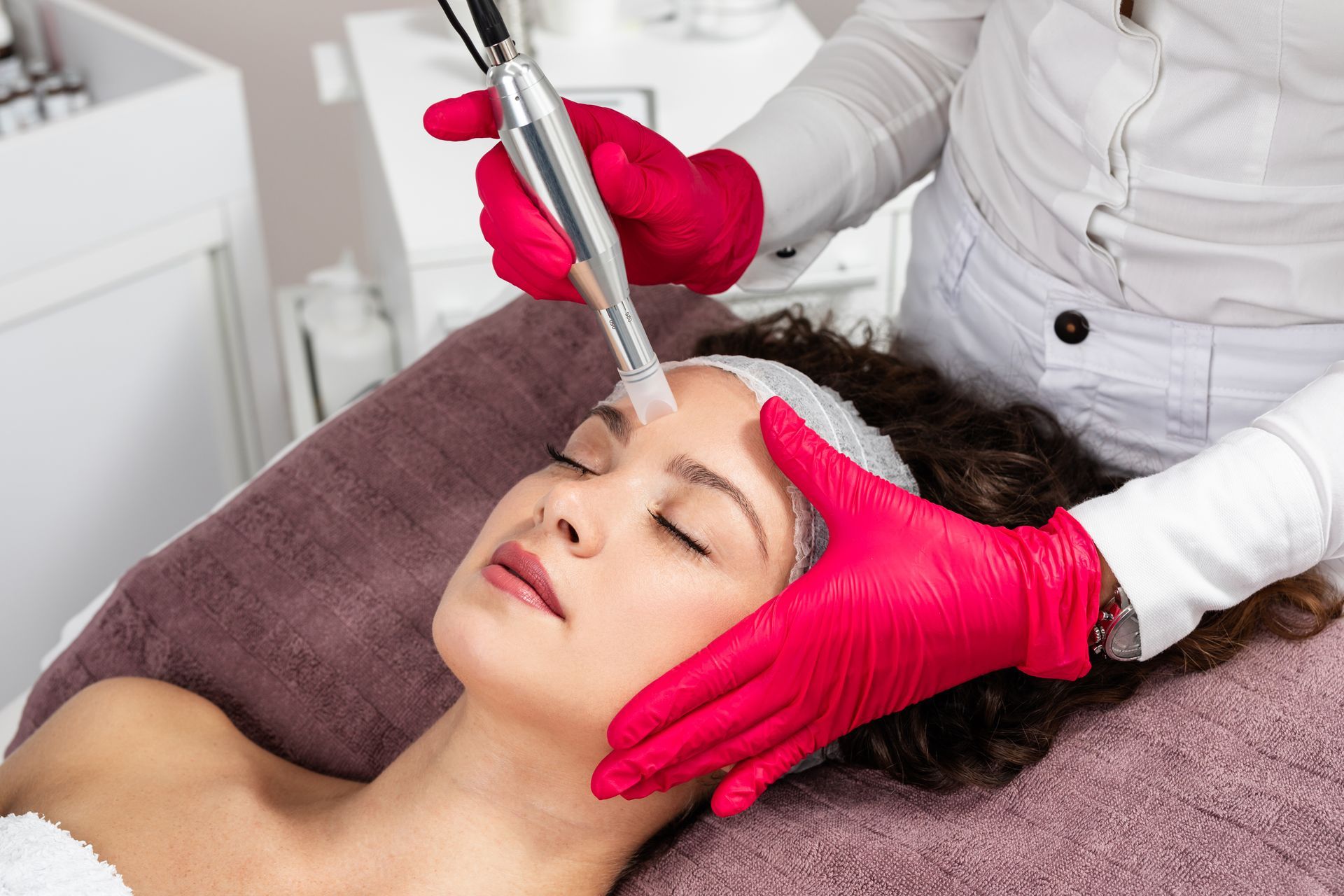 A woman is getting a facial treatment at a beauty salon.