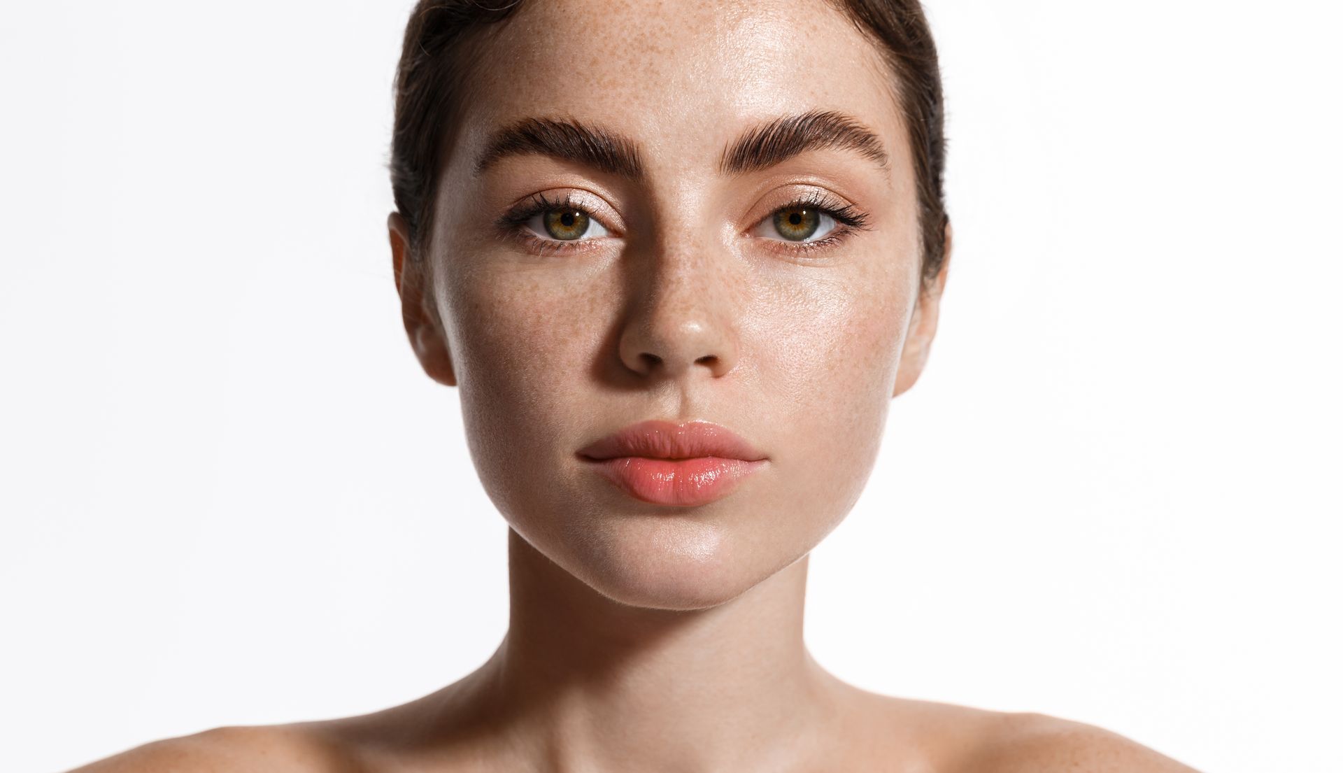 Woman with freckled skin, looking directly at the viewer, subtle makeup.