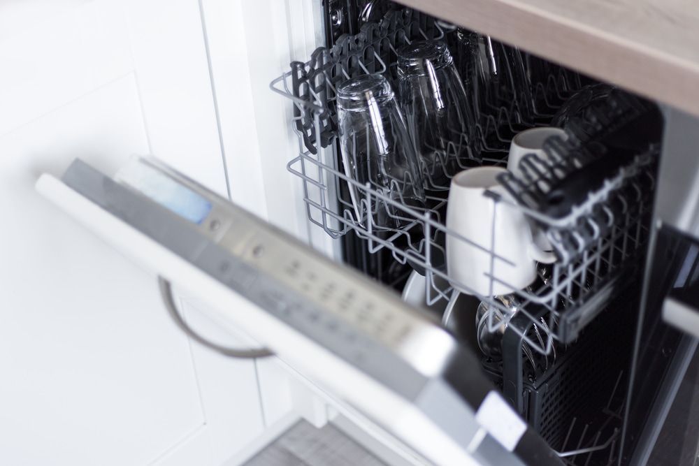 A Dishwasher is Filled With a Lot of Dishes and Cups — Patrick Lunney Home Appliance Service & Repairs in Maudsland, QLD