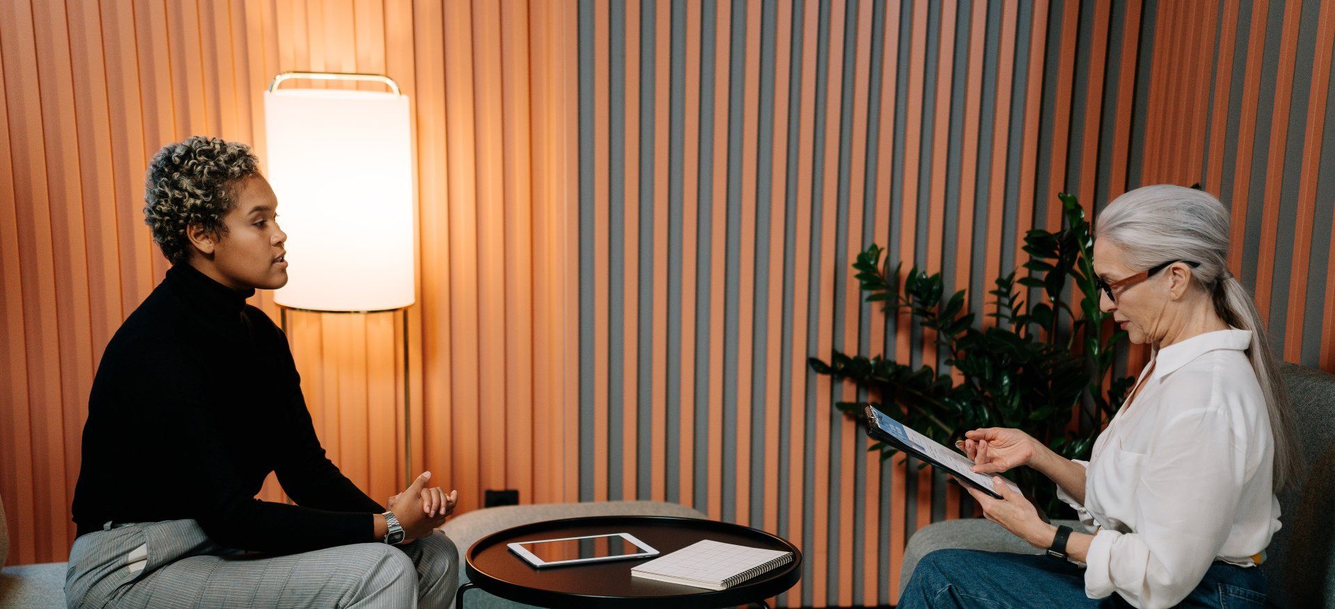 Two women are sitting at a table having a conversation.