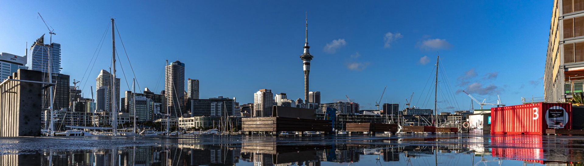 A city skyline is reflected in a body of water.