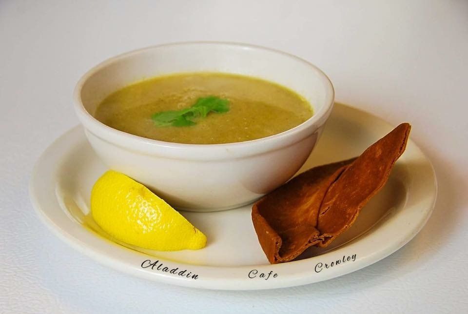 a bowl of soup with a slice of lemon on a plate