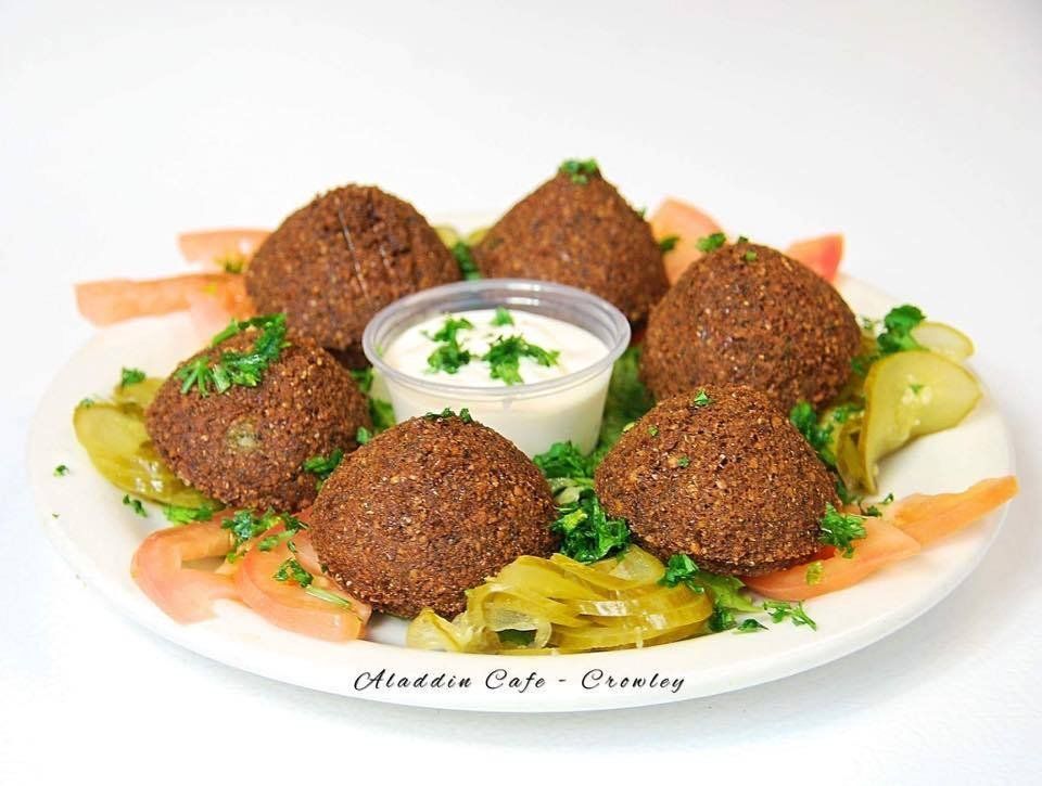 a plate of falafel and vegetables with a dipping sauce