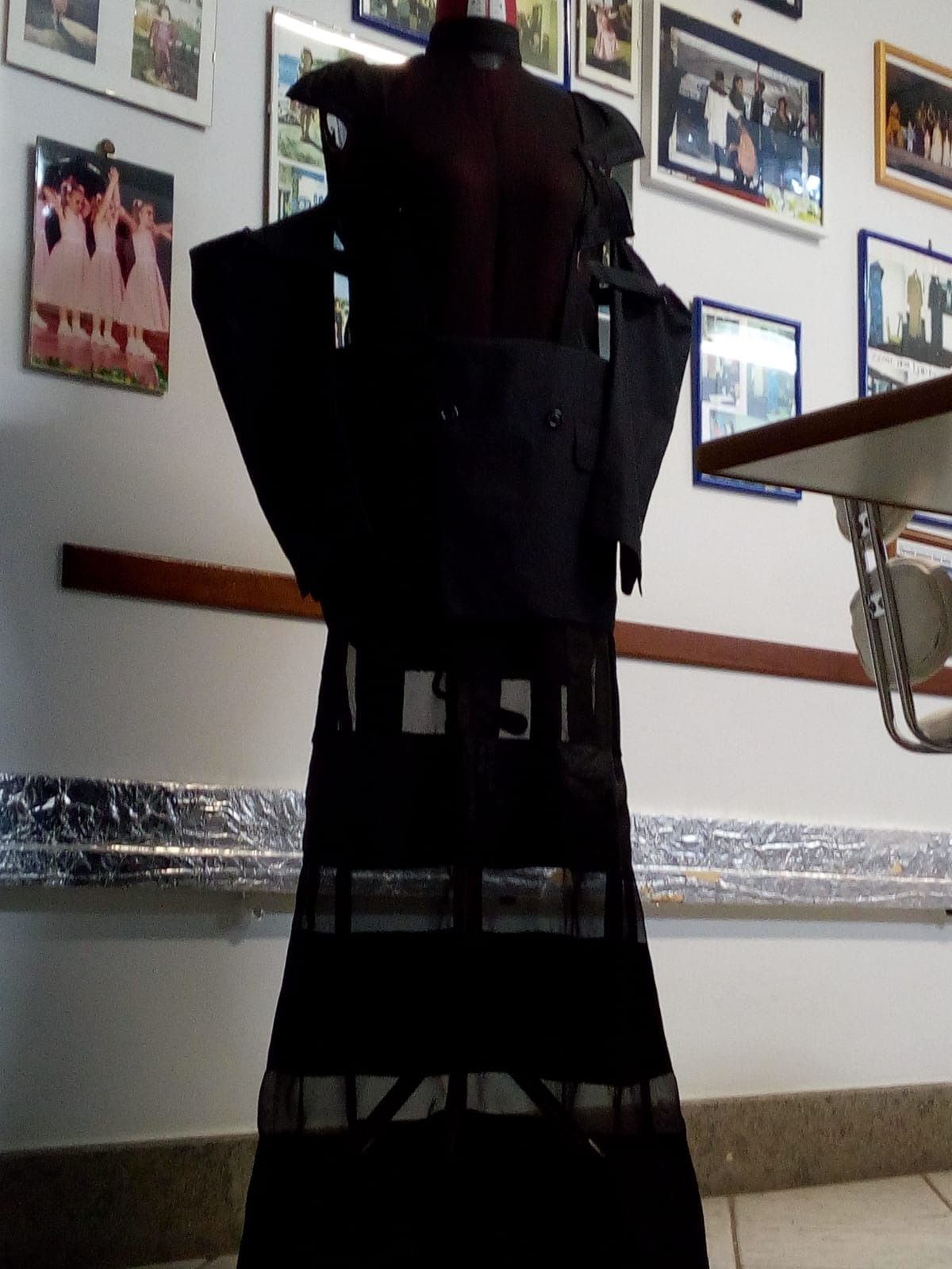 Un manichino è in piedi davanti a un muro con delle immagini sopra