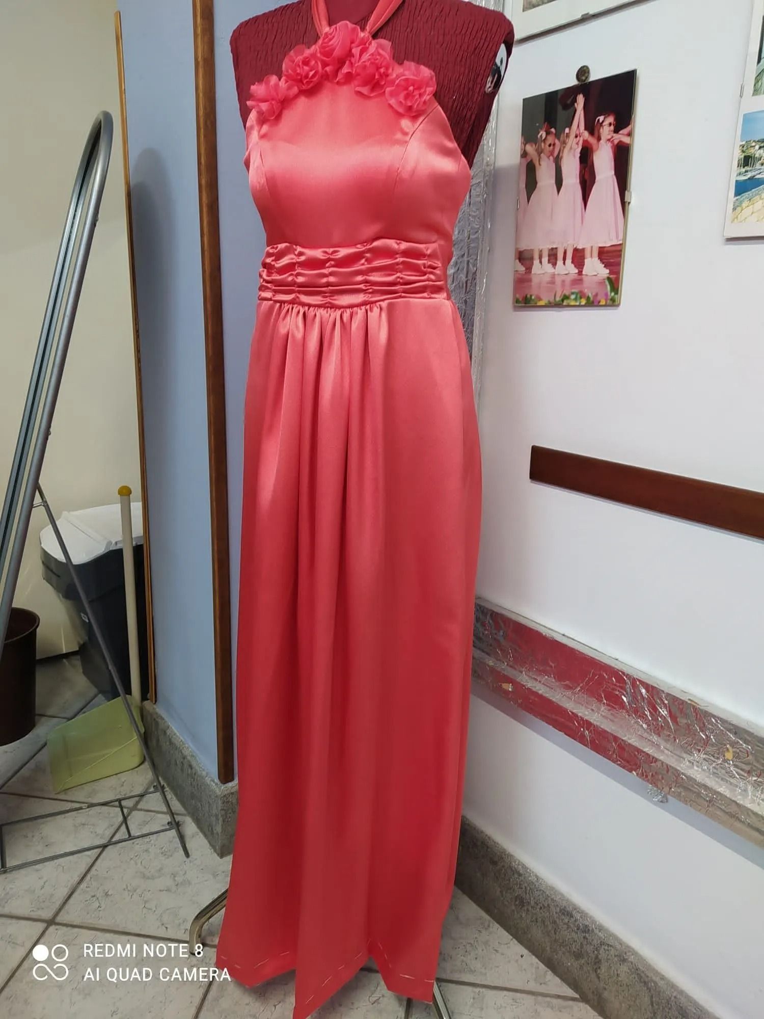 In una stanza c'è un vestito rosso su un manichino.