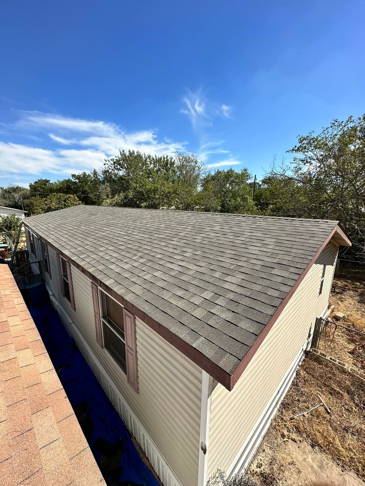 An aerial view of a mobile home with a new roof.
