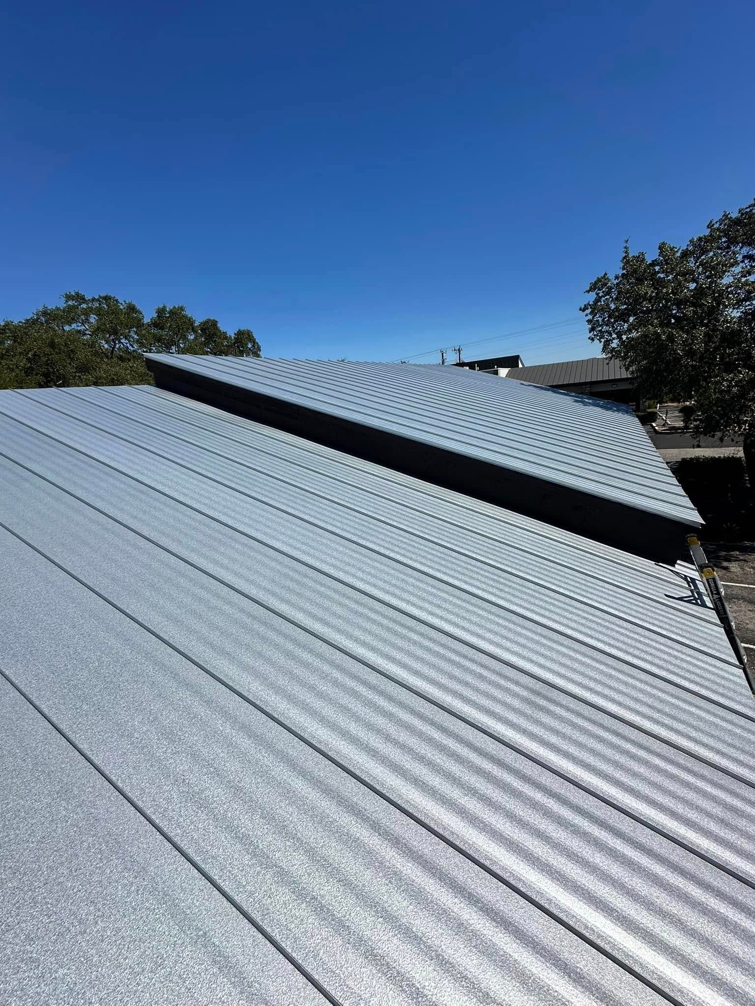 A close up of a metal roof with a blue sky in the background.