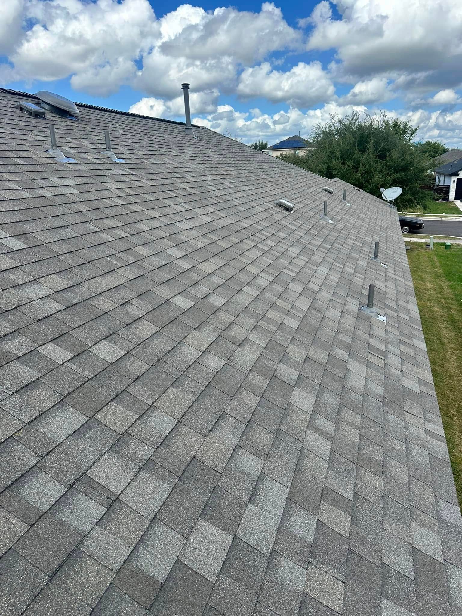 A roof with a lot of shingles on it and a chimney on top of it.