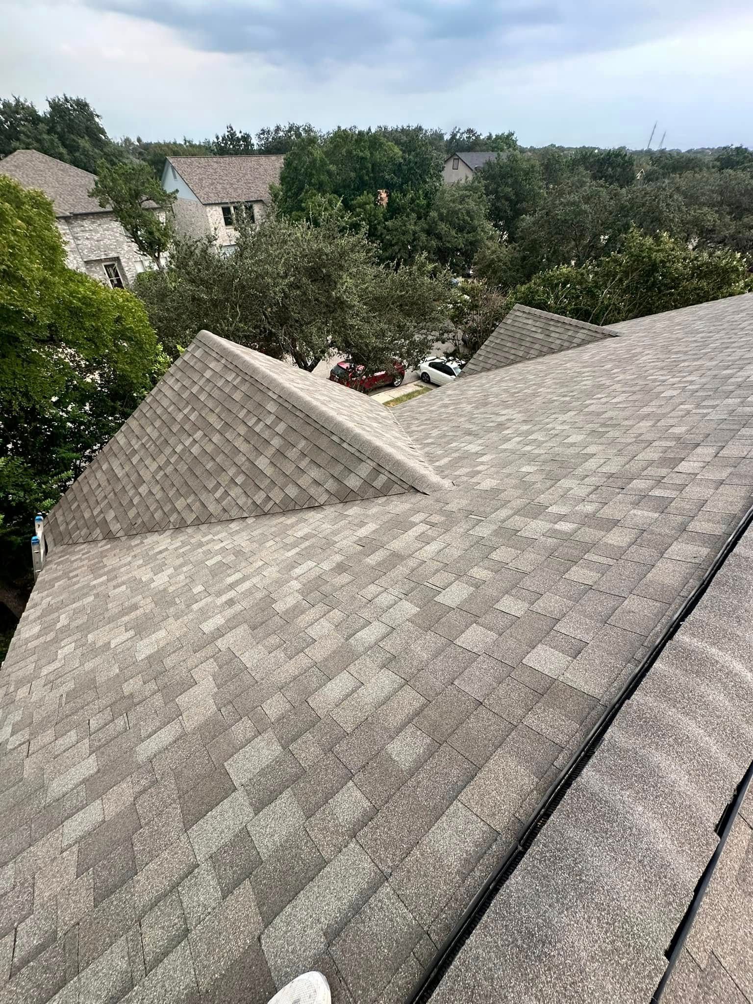 A roof with a lot of trees and houses in the background.