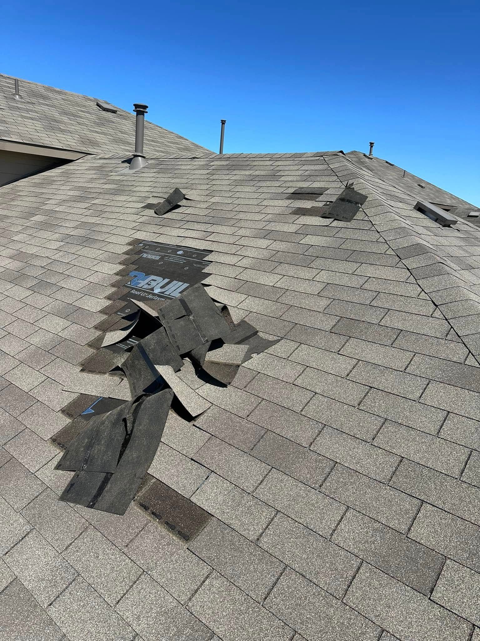 A close up of a roof with a lot of shingles missing.