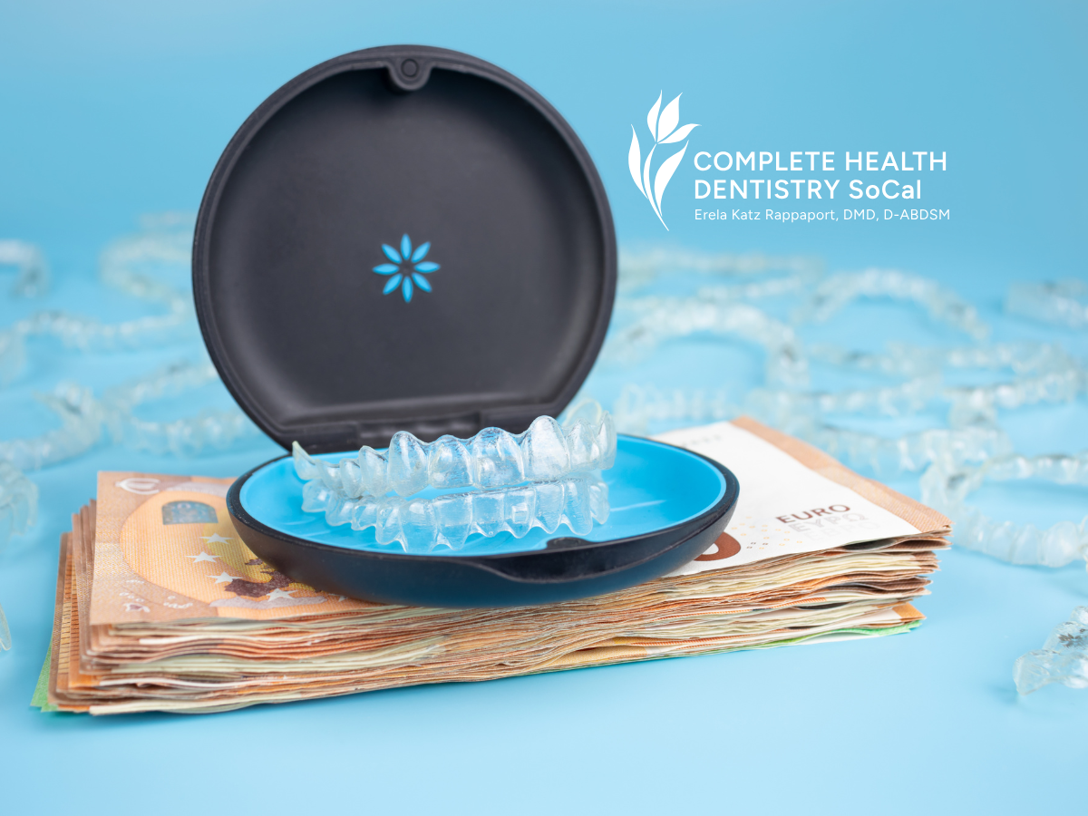 An invisalign case is sitting on top of a pile of money.