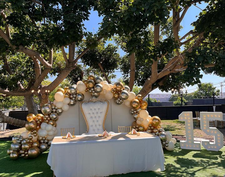 a table with balloons and a chair in front of it