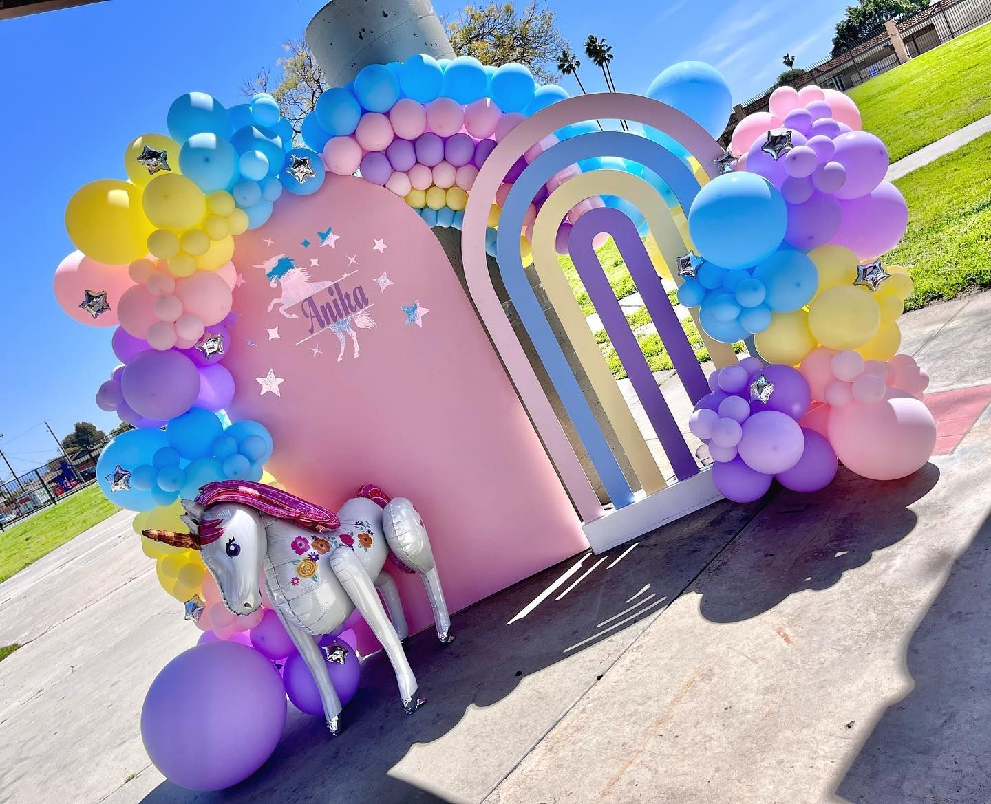 a unicorn balloon is sitting in front of a wall decorated with balloons .