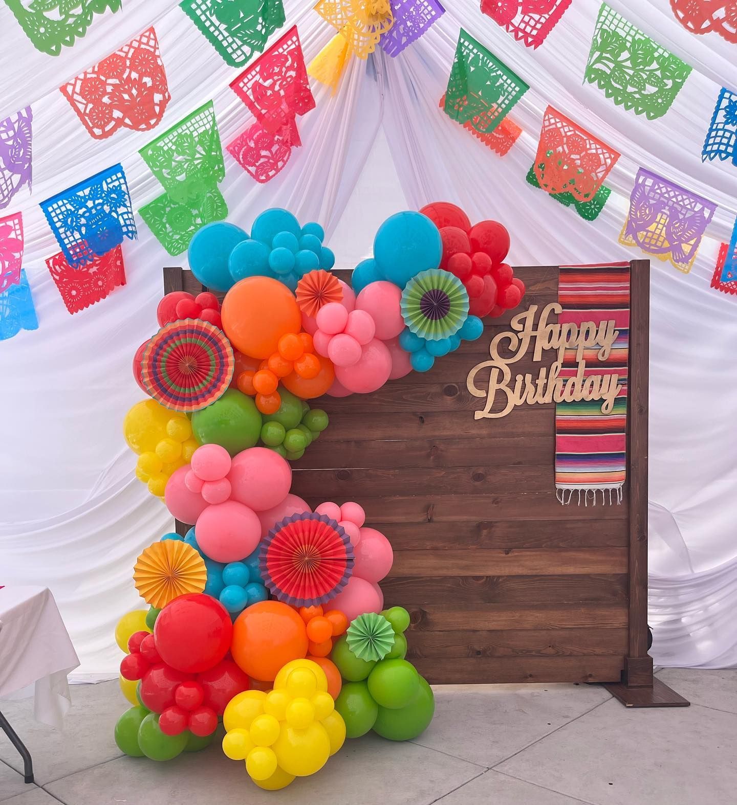 a wooden wall with balloons and a sign that says happy birthday