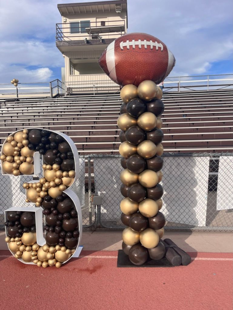 a balloon pillar with a football on top of it