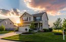 Suburban house at sunset with a manicured lawn and a driveway