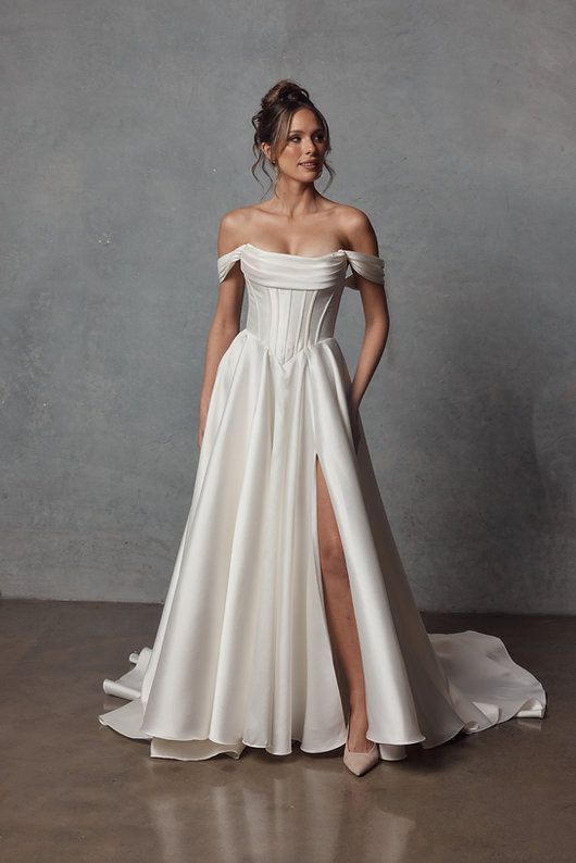 A woman is wearing a white wedding dress with a plunging neckline.