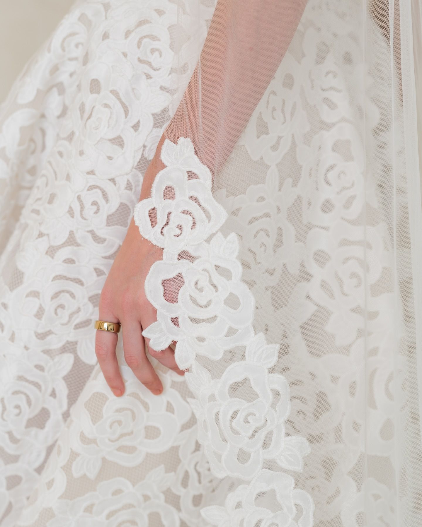 A woman wearing a wedding dress has a ring on her finger
