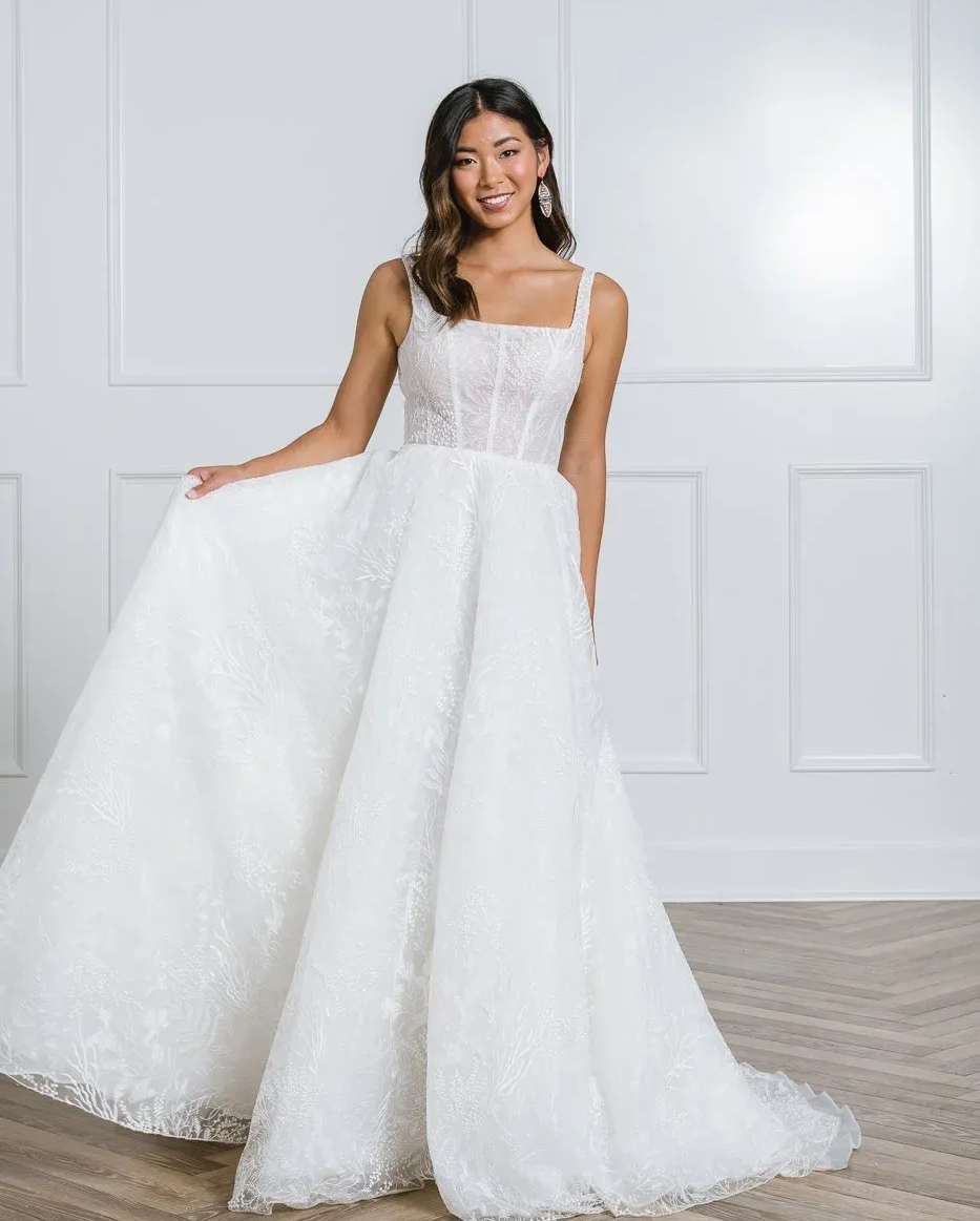 A woman is wearing a white wedding dress with a high slit.