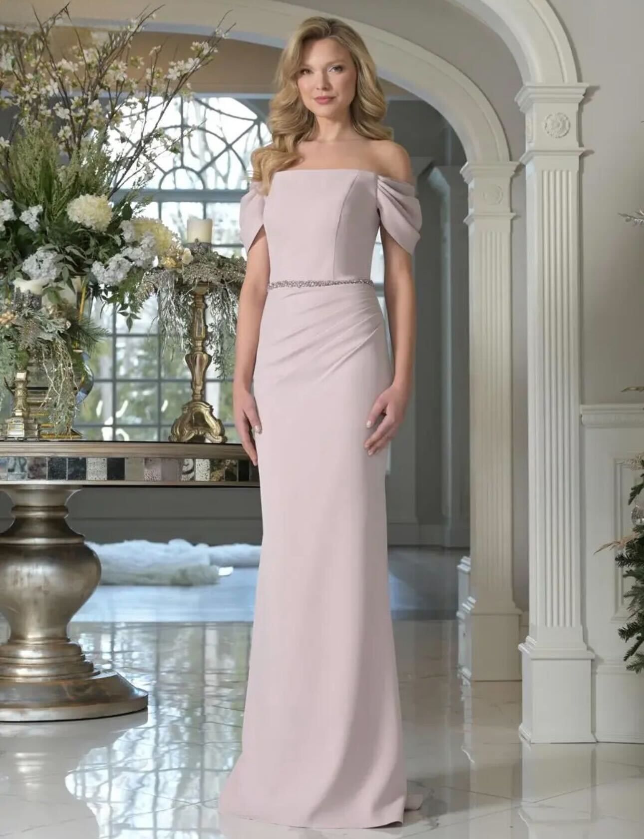 A woman is wearing a gray off the shoulder dress.