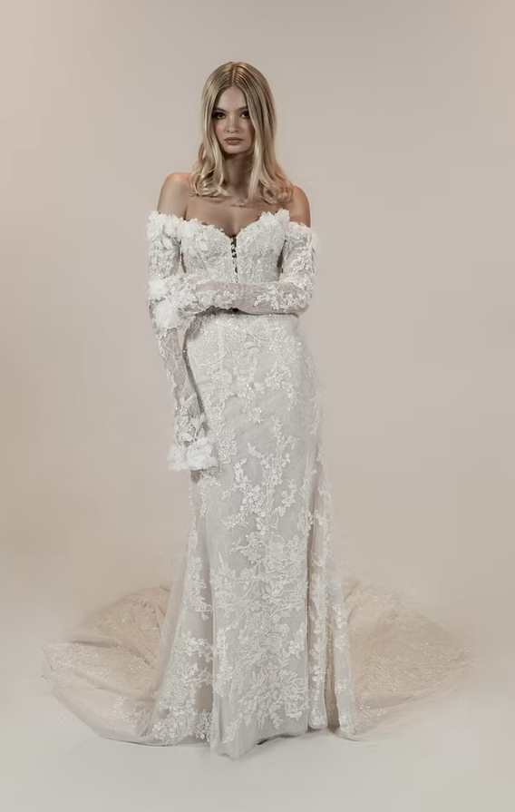 A woman is wearing a white wedding dress with a high slit.