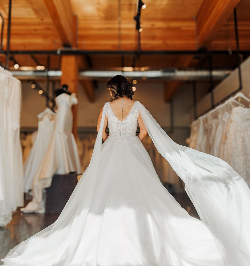 A woman in a white wedding dress is standing in a store