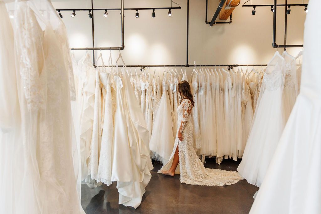 A woman in a wedding dress is standing in a bridal store.