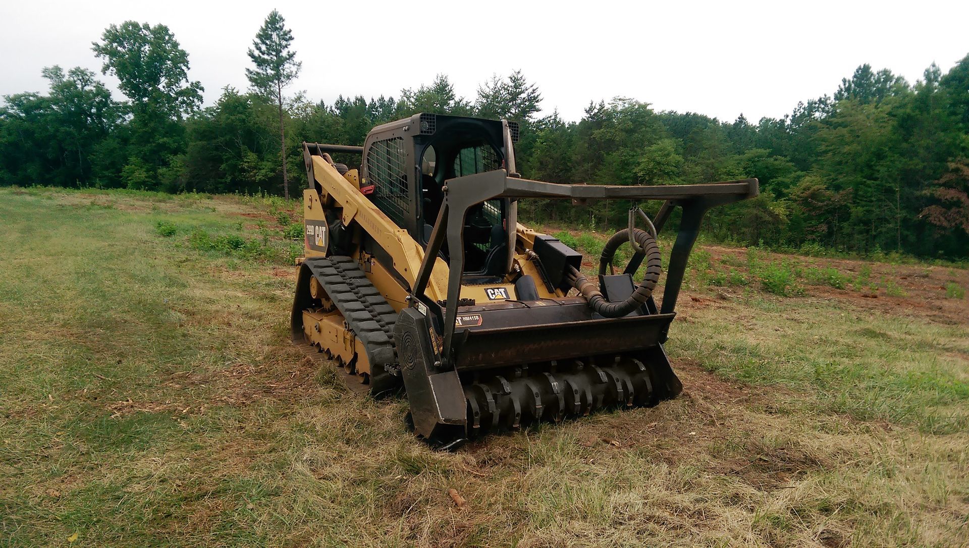 A man is working on a bulldozer on a dirt road.